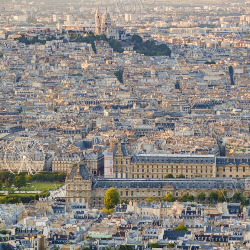 Aerial view of Paris, including the Louvre museum and Montmartre Cathedral.