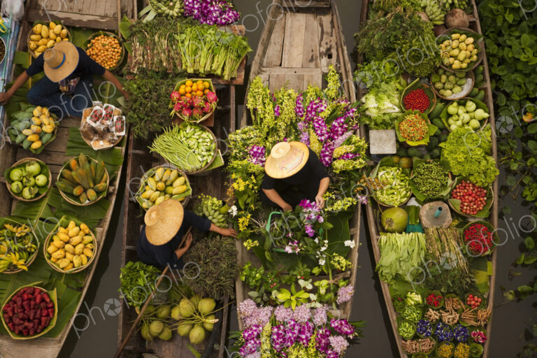 Aerial view of a floating market on a canal in Bangkok, local boats laden with fresh…