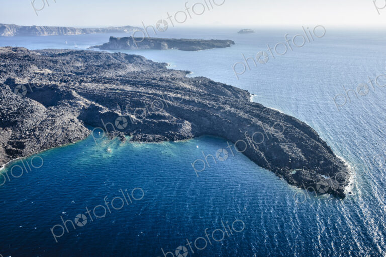 Aerial view of a headland on a island in the Aegean sea, volcanic rock formations,…