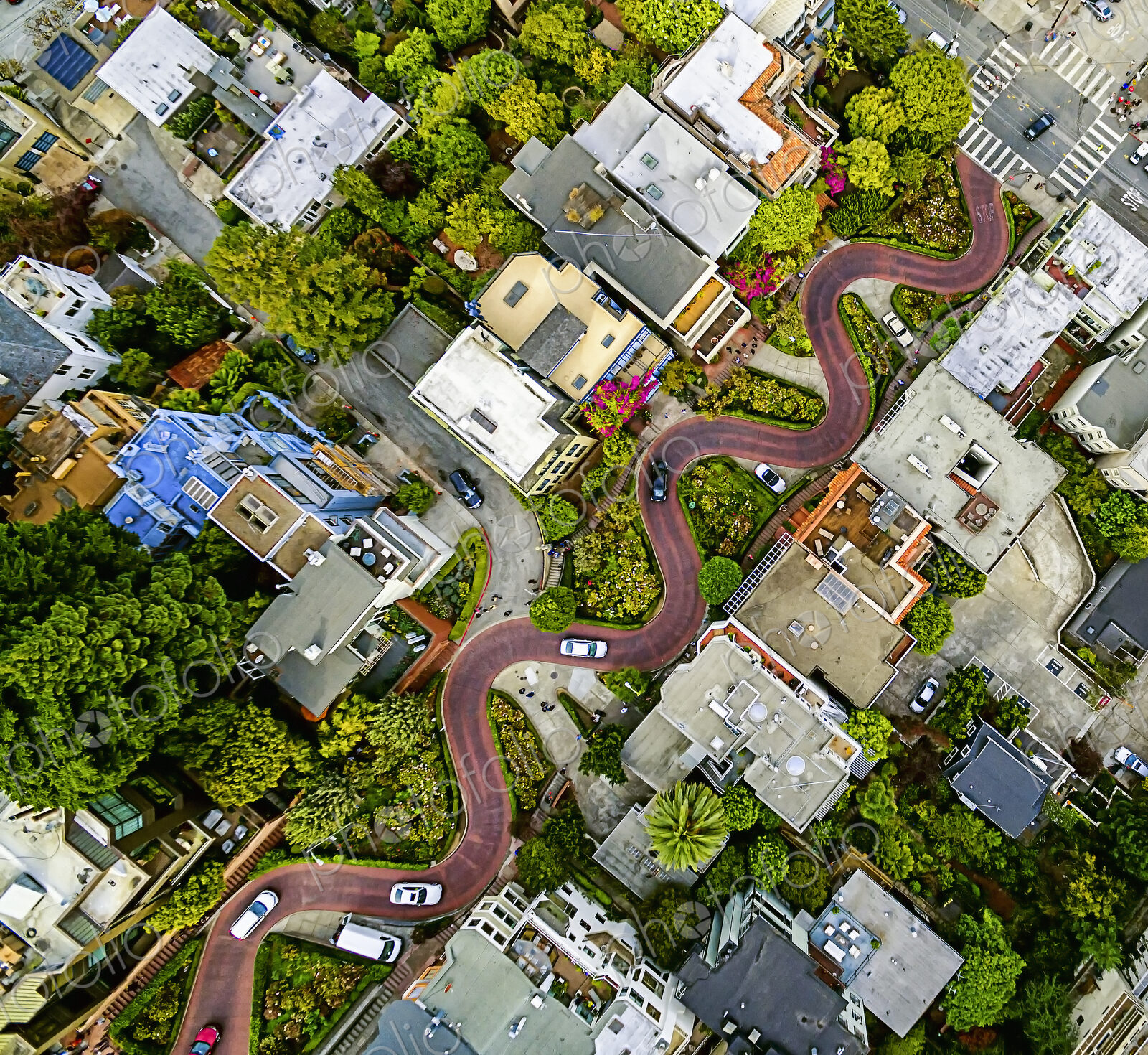 Aerial view of a residential city area, with road descending a hillside with eight…