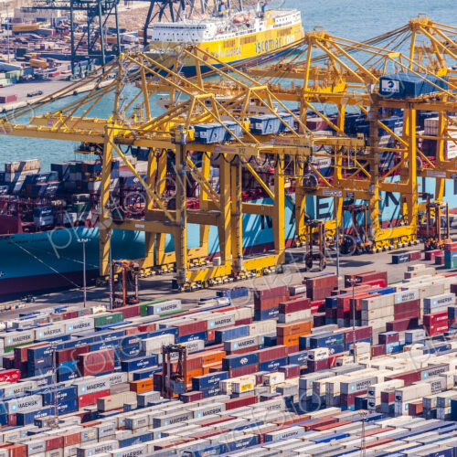Aerial view of cranes and containers in urban shipyard