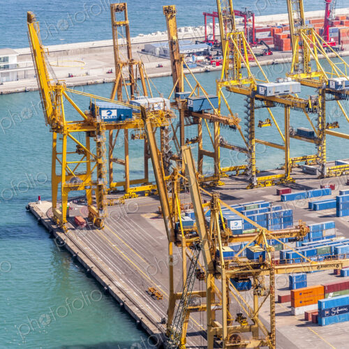 Aerial view of cranes and containers in urban shipyard