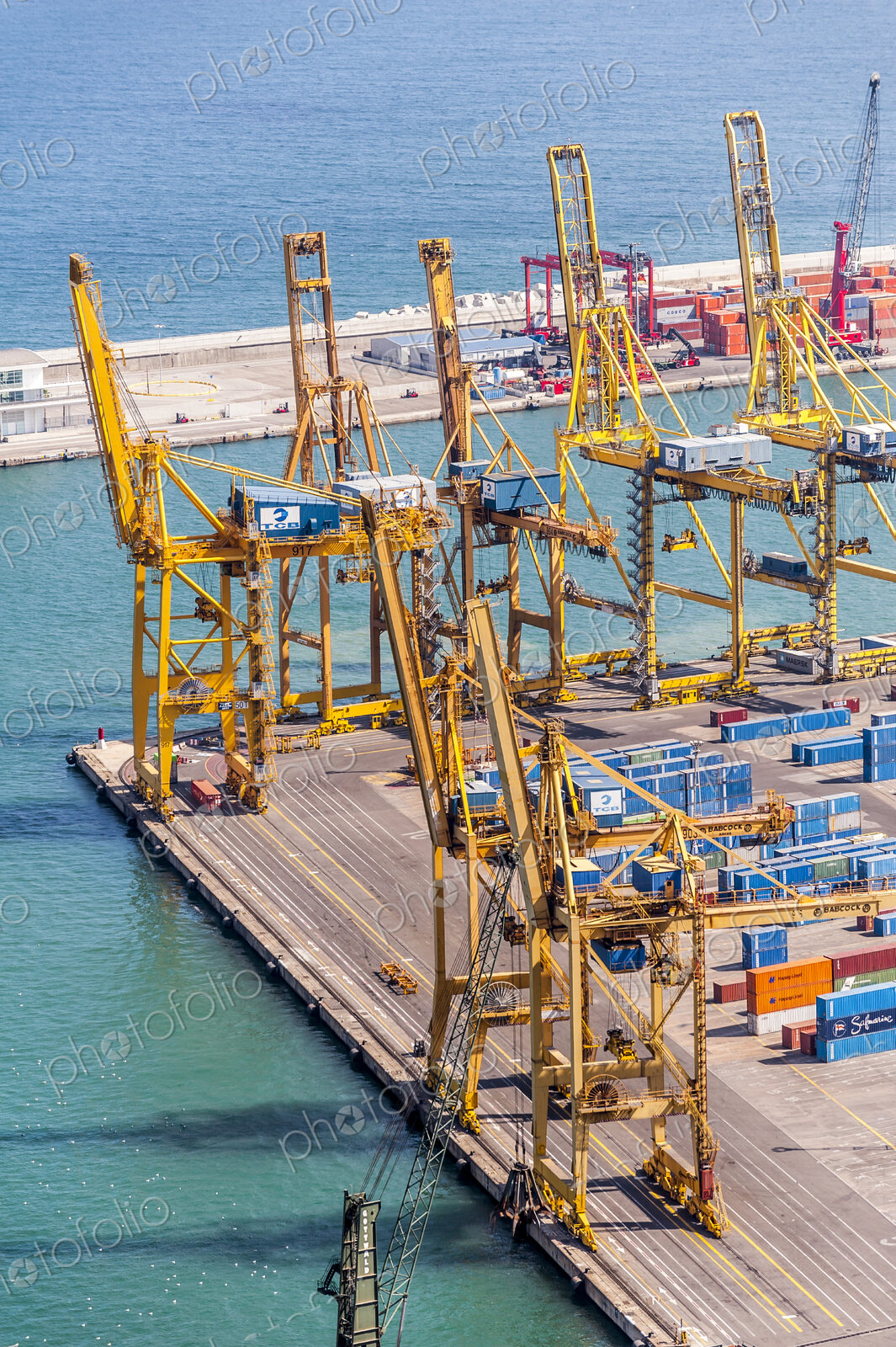 Aerial view of cranes and containers in urban shipyard