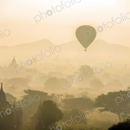 Aerial view of hot air balloons flying over towers