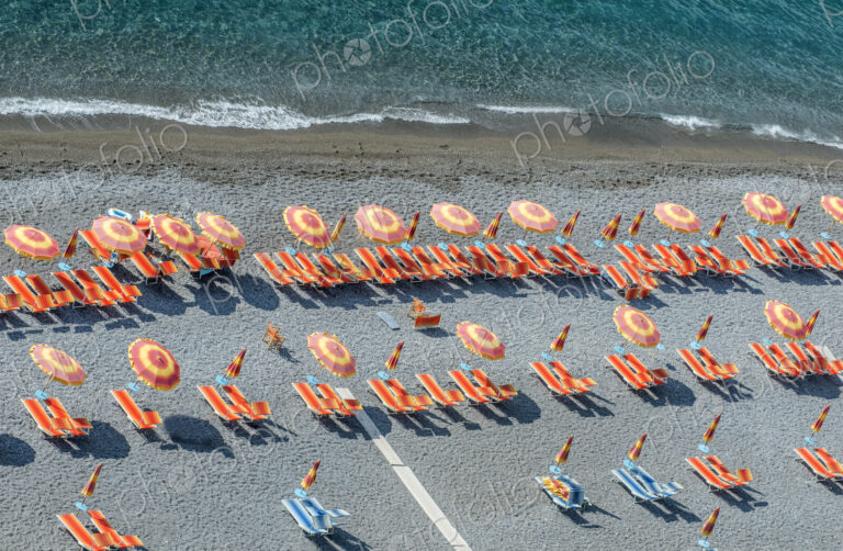 Aerial view of lawn chairs and umbrellas on beach