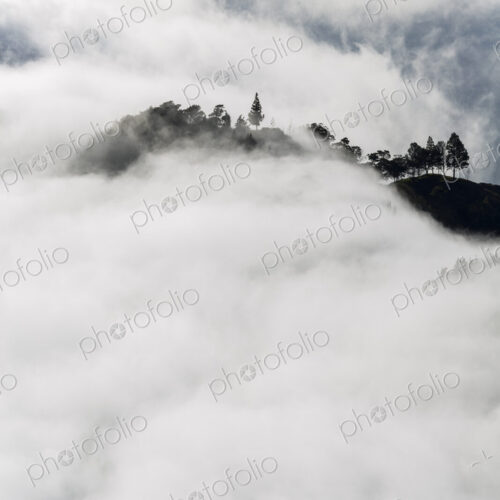 Aerial view of lush mountains on an island, surrounded by clouds. Aerial view of lush mountains on an island, surrounded by clouds.