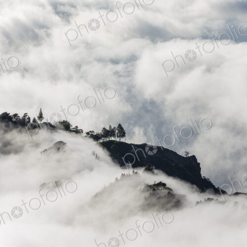 Aerial view of lush mountains on an island, surrounded by clouds. Aerial view of lush mountains on an island, surrounded by clouds.