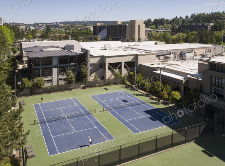 Aerial view of tennis court and people playing tennis.