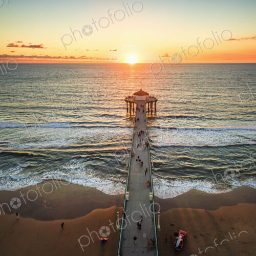 Aerial view of the Manhattan Beach Pier and waves breaking on the shore. Aerial view of the Manhattan Beach Pier and waves breaking on the shore.