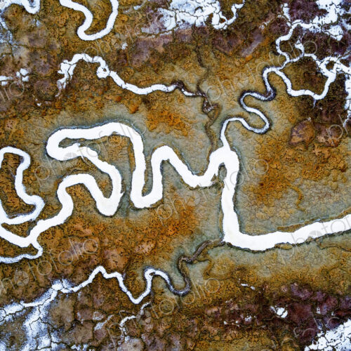 Aerial view of the landscape, meandering water channels and the salt pans with white… Aerial view of the landscape, meandering water channels and the salt pans with white…