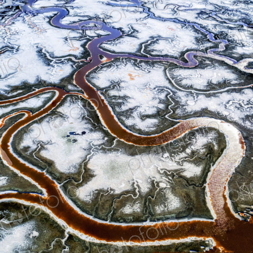 Aerial view of the landscape, meandering water channels and the salt pans with white… Aerial view of the landscape, meandering water channels and the salt pans with white…