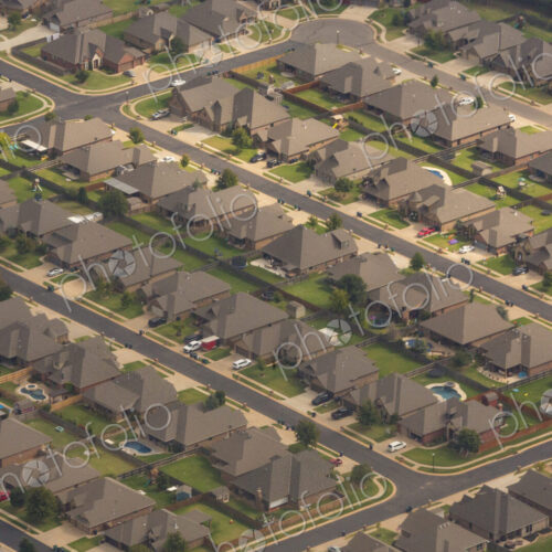 Aerial view over a suburb of residential buildings, houses build in a neat grid…