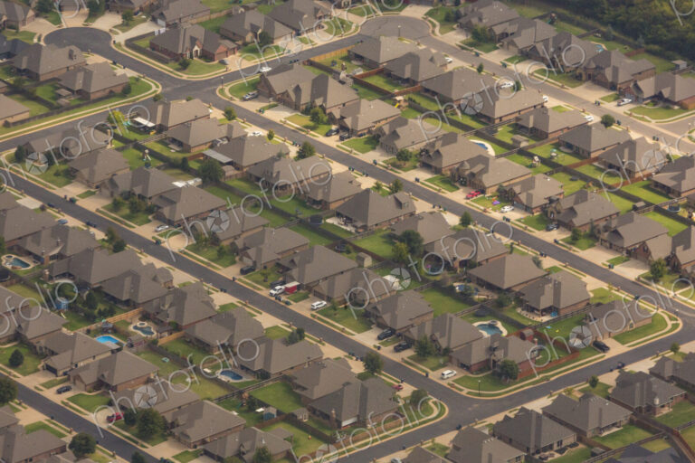Aerial view over a suburb of residential buildings, houses build in a neat grid…