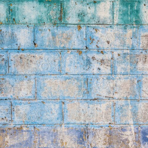 Aged and textured cinder block wall with fading blue, green, and purple paint in Isla… Aged and textured cinder block wall with fading blue, green, and purple paint in Isla…