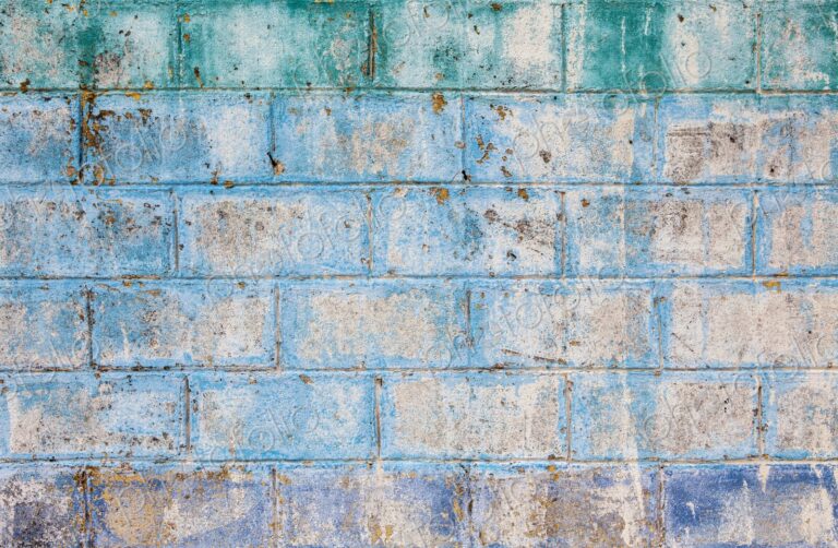 Aged and textured cinder block wall with fading blue, green, and purple paint in Isla…