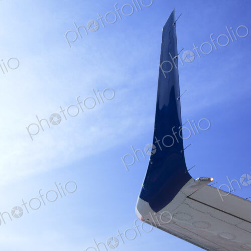Aircraft wingtip, low angle view, against blue sky.