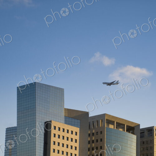Airplane Flying Over Office Buildings