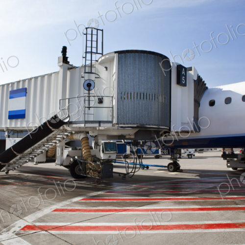 Airport buildings, airbridge for passengers, and aircraft on the ground