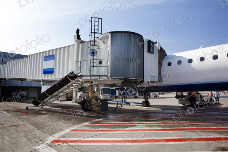 Airport buildings, airbridge for passengers, and aircraft on the ground