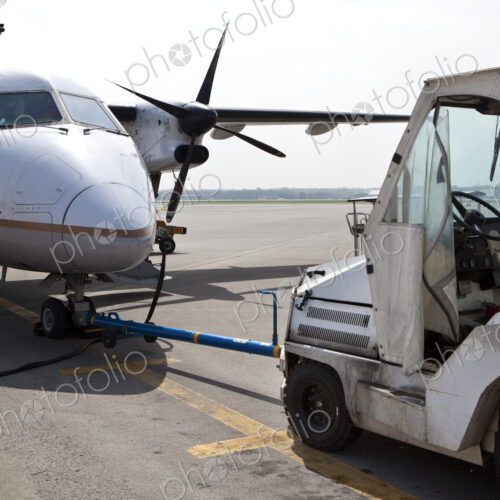 Airport vehicle towing a propeller aircraft into position Airport vehicle towing a propeller aircraft into position