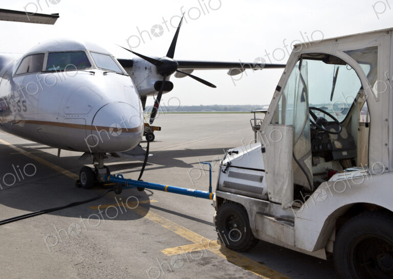 Airport vehicle towing a propeller aircraft into position