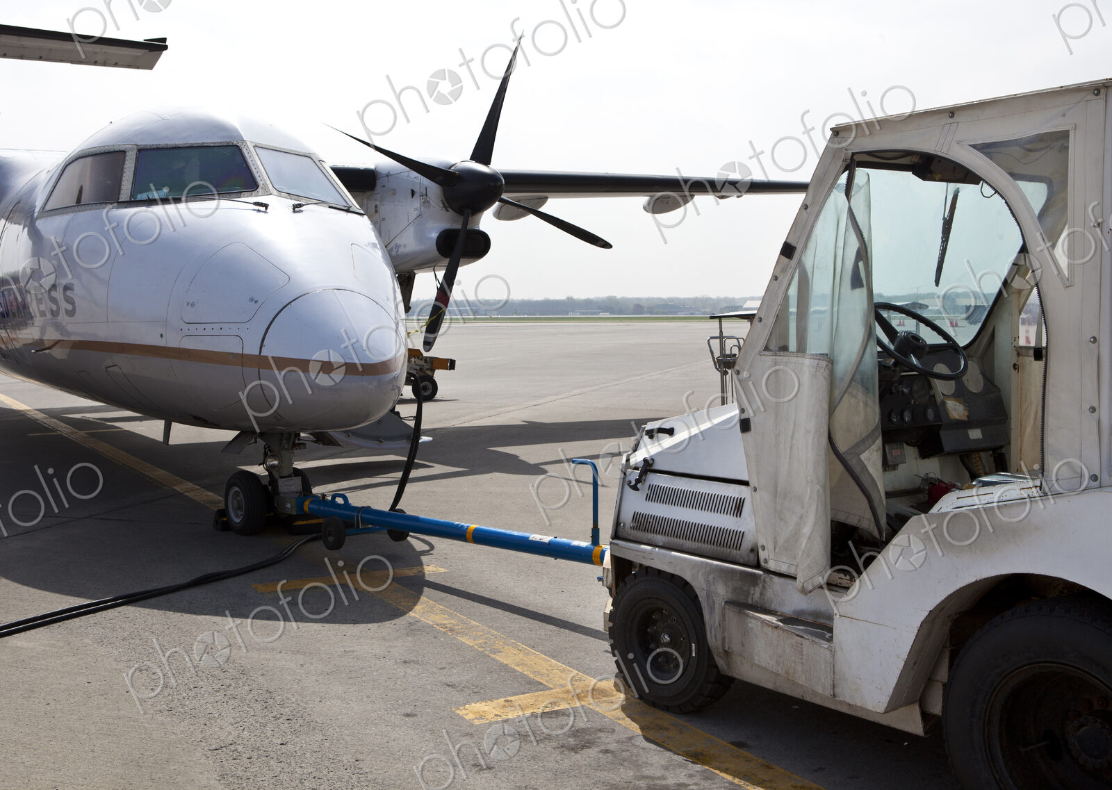 Airport vehicle towing a propeller aircraft into position