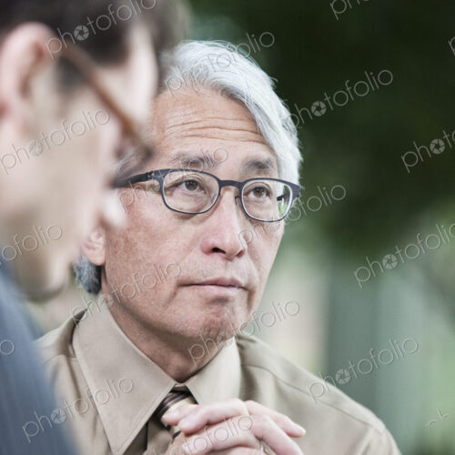An Asian businessman and Caucasian businessman working on lapt top computer An Asian businessman and Caucasian businessman working on lapt top computer