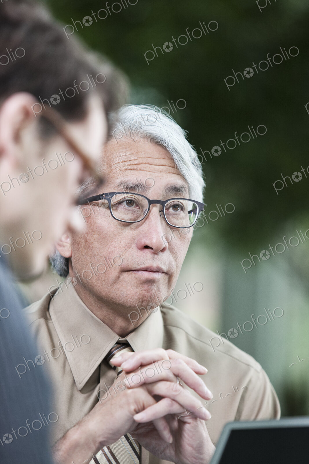 An Asian businessman and Caucasian businessman working on lapt top computer