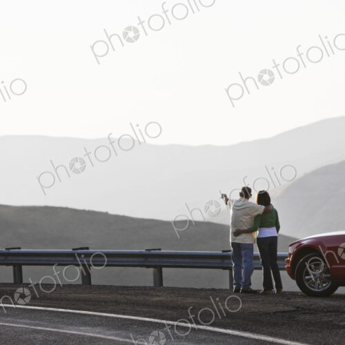 An Hispanic senior couple enjoying the scenery from a rest stop on a highway
