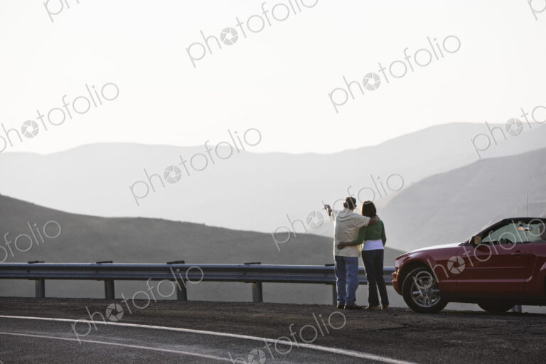 An Hispanic senior couple enjoying the scenery from a rest stop on a highway