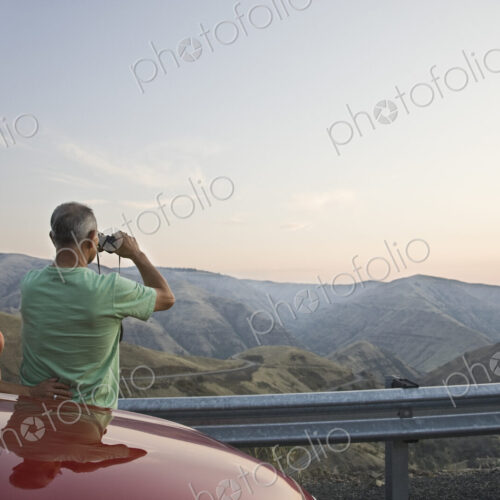 An Hispanic senior couple enjoying the scenery from a rest stop on a highway