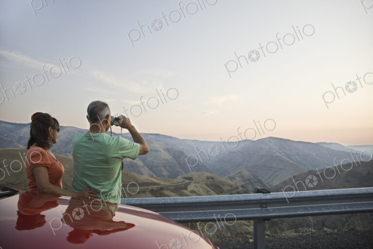 An Hispanic senior couple enjoying the scenery from a rest stop on a highway