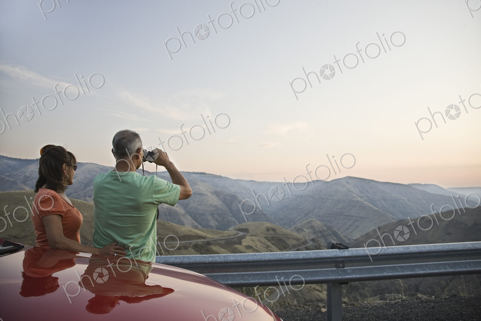 An Hispanic senior couple enjoying the scenery from a rest stop on a highway