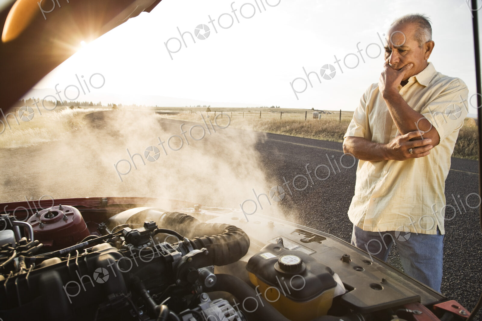 An Hispanic senior man pulled over at the side of the road with engine trouble.