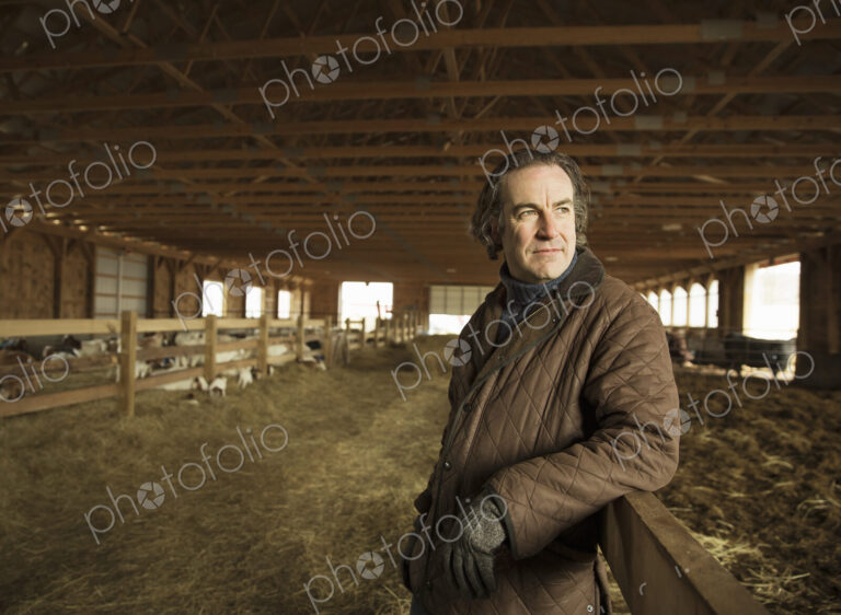 An Organic Farm in Winter in Cold Spring, New York State. A farmer in a livestock barn…
