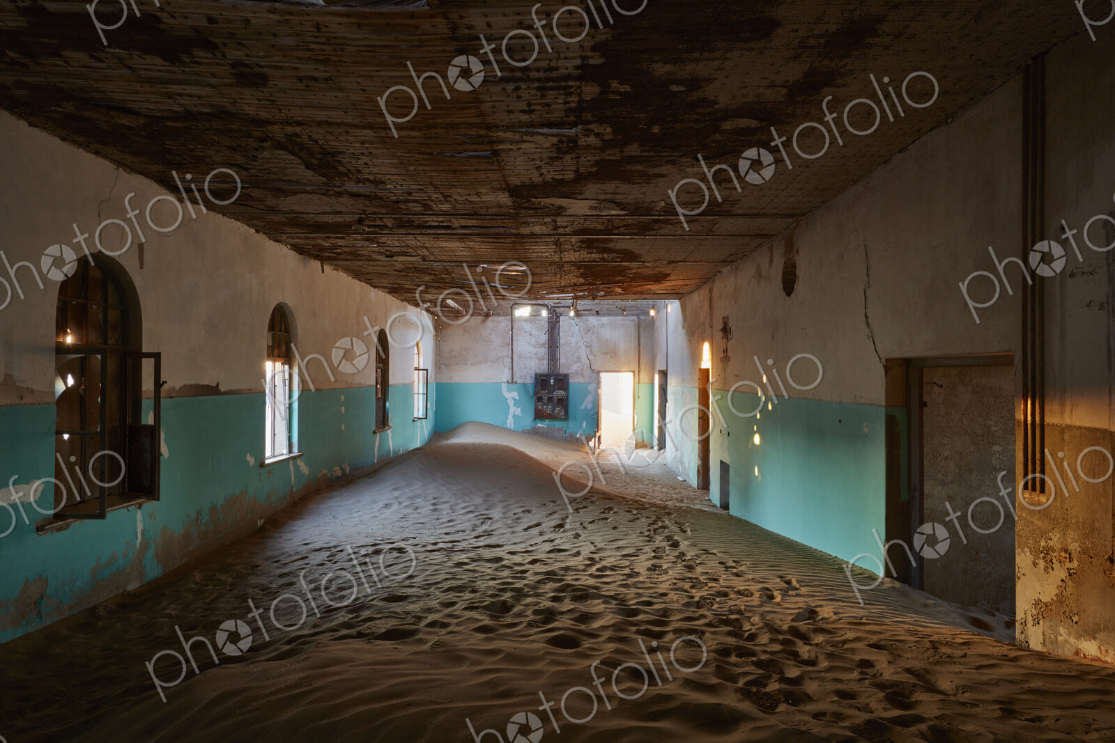 An abandoned building with boarded up windows, and shafts of sunlight lighting up the…