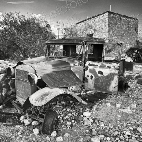 An abandoned classic vintage motor car, with rusting bent metal, no windows and bare…