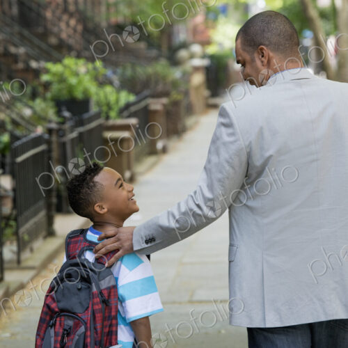 An adult and a child, a father and son, walking together on the street in the city. An adult and a child, a father and son, walking together on the street in the city.