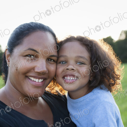An adult woman and a child, mother and son, outdoors in evening light.