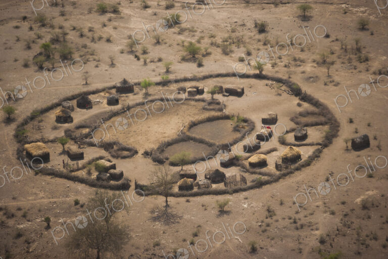 An aerial view of a small rural village settlement, with traditional buildings and…
