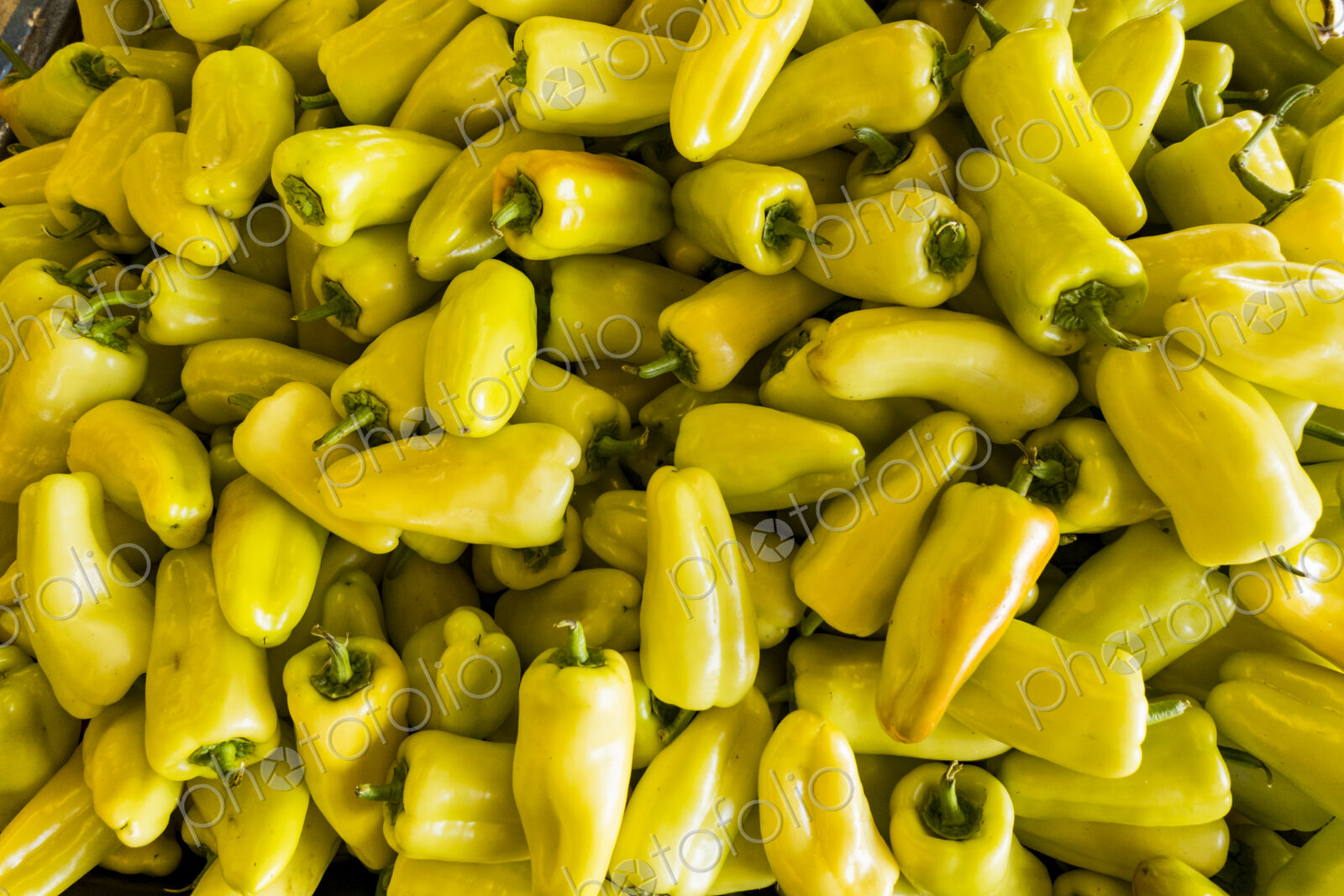 An agricultural market stall, close up of yellow chili peppers.