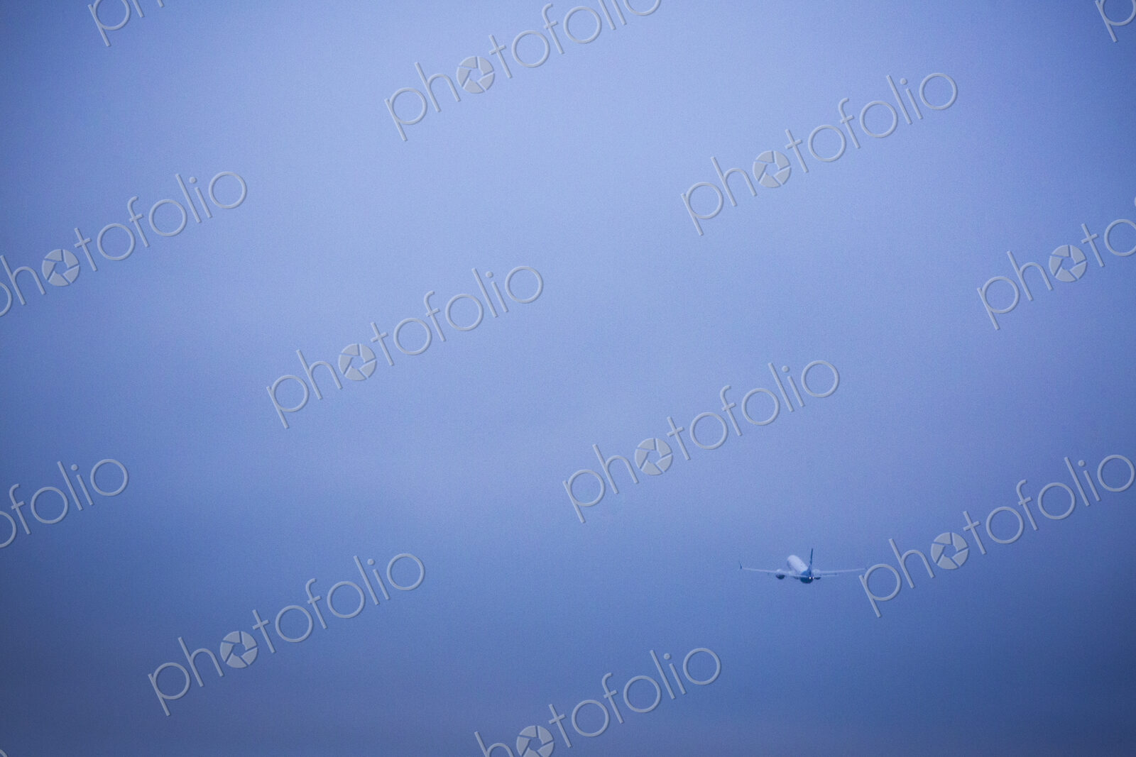 An aircraft taking off in a clear blue sky.