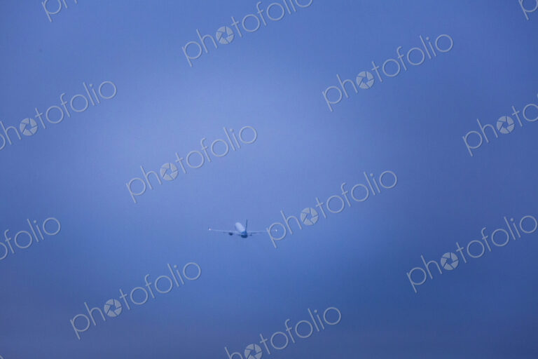 An aircraft taking off in a clear blue sky.