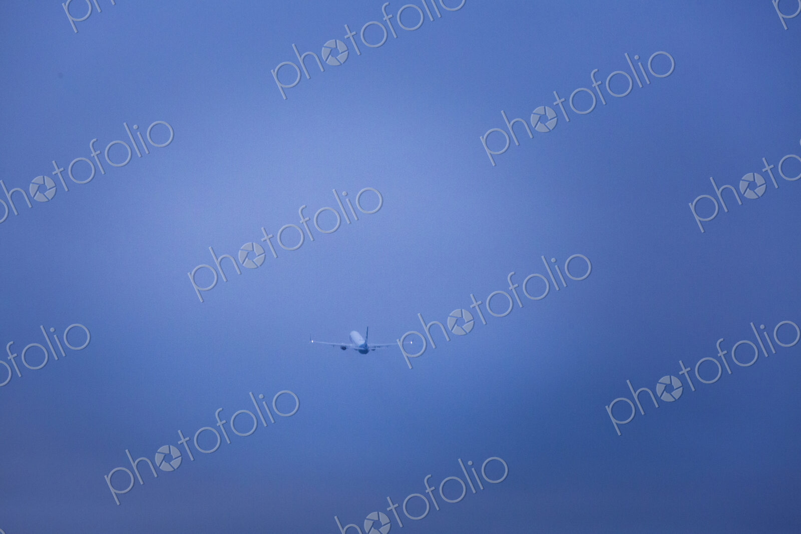 An aircraft taking off in a clear blue sky.