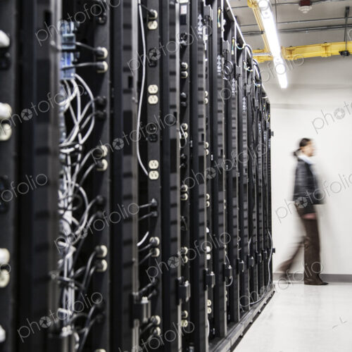 An aisle of racks in a computer server farm. An aisle of racks in a computer server farm.