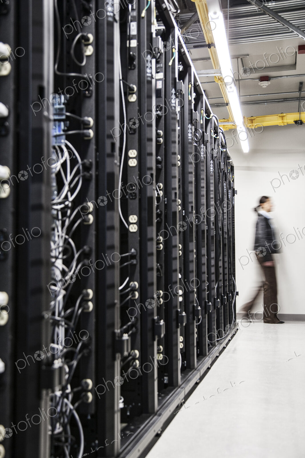 An aisle of racks in a computer server farm.