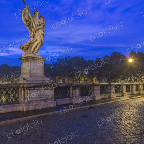 An angel statue on the bridge Ponte Sant'Angelo, at dusk