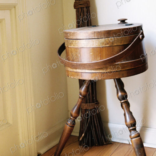 An antique object, a three legged ice box or container in the corner of a room. An antique object, a three legged ice box or container in the corner of a room.