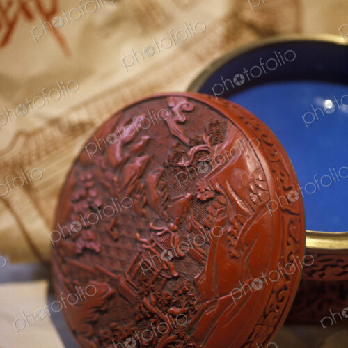 An antique red lacquer bowl with a lid.