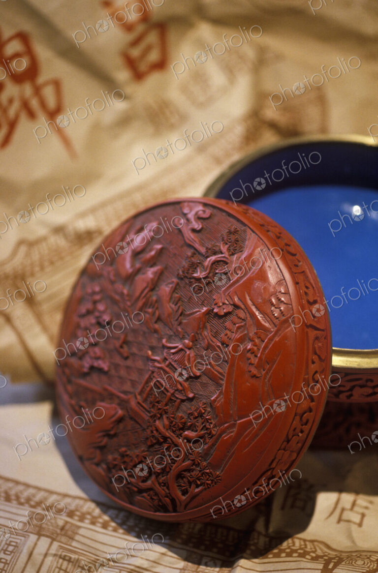 An antique red lacquer bowl with a lid.